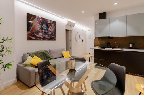 阿尔巴塞特Apartamentos TriBeCa Centro I的厨房以及带玻璃桌的起居室。