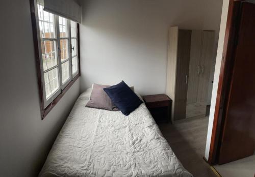洛斯比洛斯MARITIMO SUITE的一间卧室配有一张带枕头和窗户的床