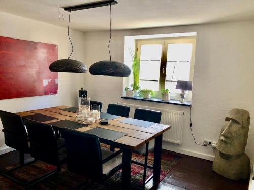 RiedenFerienhaus Eifel-Auszeit的一间带木桌和椅子的用餐室