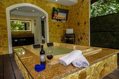 QuesadaPalo Alto Glamping Hotel的浴缸配有一瓶葡萄酒和玻璃