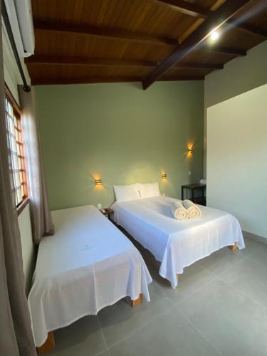 皮雷诺波利斯Pousada Portal do Cerrado的一间卧室配有两张带白色床单的床