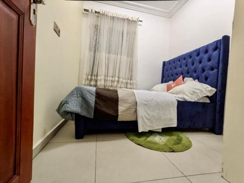 雅温得Appartement meublé haut standing 1CH en RDC的一间卧室配有蓝色的床和地毯
