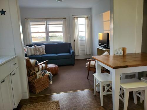 新肖雷汉姆Barrington Inn Barn的客厅配有蓝色的沙发和桌子