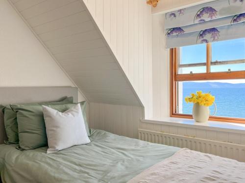 阿普尔克罗斯The Fishermans Cottage的一间卧室设有一张床和一个海景窗户