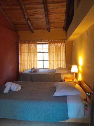 奥兰太坦波B&B Sun Gate的一间卧室设有两张床和窗户。