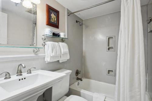 新奥尔良皮埃尔·拉菲特公寓式酒店的白色的浴室设有水槽、卫生间和淋浴。