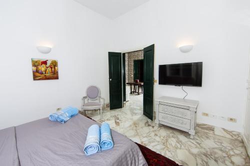 拉马萨Arabesque House的一间卧室配有一张床和一台平面电视