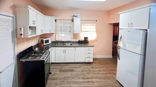 巴斯特尔Lulu cottage的厨房配有白色橱柜和白色冰箱。