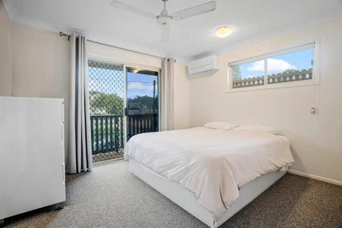 布里斯班Luxurious Urban Eco Escape 3br的一间白色卧室,配有床和阳台