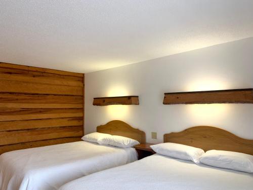 TomahawkBridge Inn Tomahawk -1st Floor, 2 Queen Size Bed, Walkout, River View的配有白色床单的酒店客房内的两张床