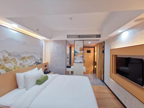 深圳广纳酒店（深圳福田店）的卧室配有一张白色大床和一台平面电视。