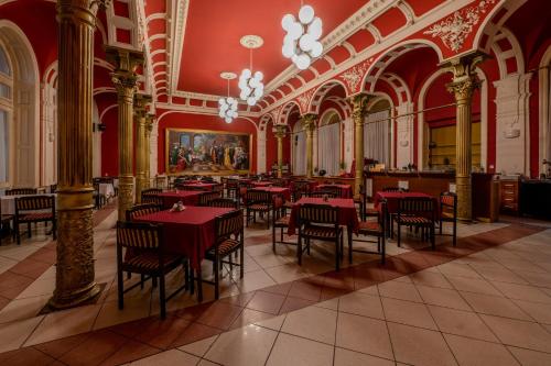 尼赖吉哈佐卡罗纳酒店的大楼内一家餐厅,配有红色的桌椅