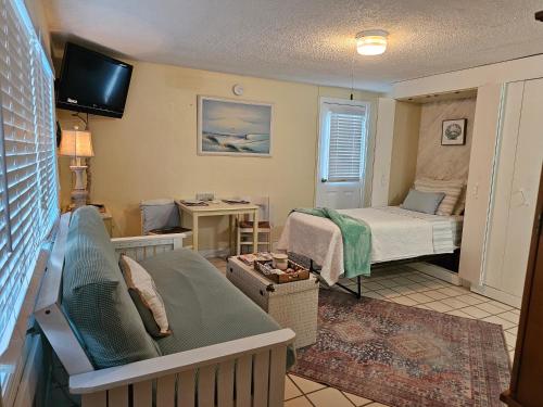 克利尔沃特Coral Resort D4的一间小房间,配有一张床,一间配有沙发的房间