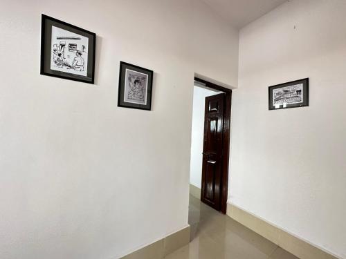 迈索尔Malgudi House - Commandant的墙上有三幅画的走廊和一扇门