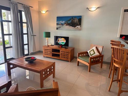 拉迪格岛卡巴内德艾格莉丝酒店的客厅配有电视和桌椅