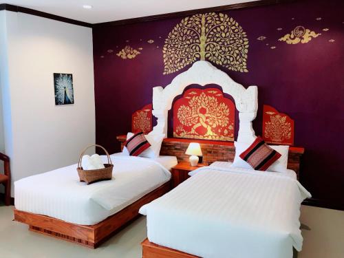 素可泰Phiphu Art and Gallery Boutique Sukhothai的紫色墙壁客房的两张床