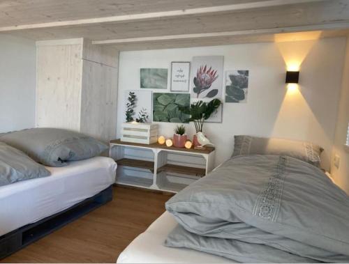 WilhelmsthalTinyhouse Wald(t)raum的一间卧室设有两张床和一张植物桌子