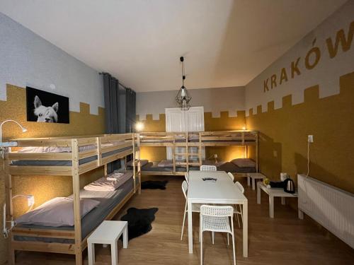 克拉科夫Girls Hostel的客房设有双层床和桌椅。