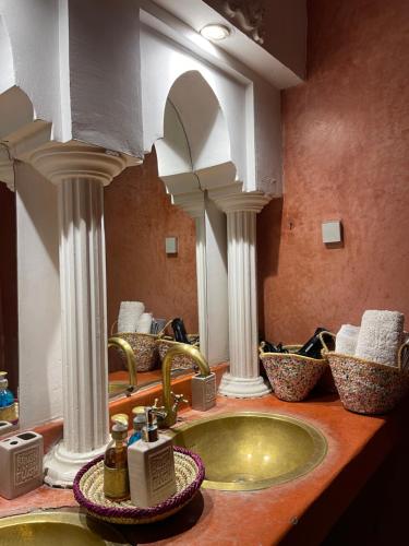 马拉喀什Riad La Calèche & SPA的一间带水槽和两面镜子的浴室