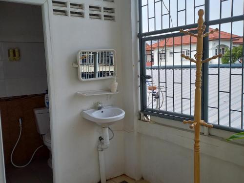 曼谷Happy Hostel的一间带水槽和窗户的浴室