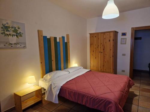 罗卡拉索Residenze Macerelli的一间卧室配有一张床和一个木制橱柜