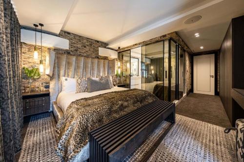 开普敦Aurum 101的一间卧室设有一张大床和石墙
