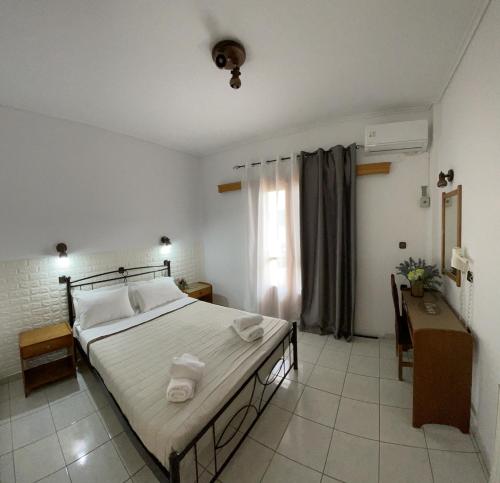 奈德里Oscar Hotel Lefkada的一间卧室配有一张床、一张书桌和一个窗户。