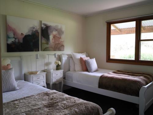 马奇Shawwood Cottage的一间卧室设有两张床和窗户。