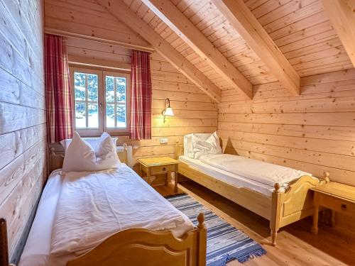沃尔夫斯堡1A Chalet Koralpenzauber - Wandern, Sauna, Grillen mit Traumblick的小木屋内带两张床的房间