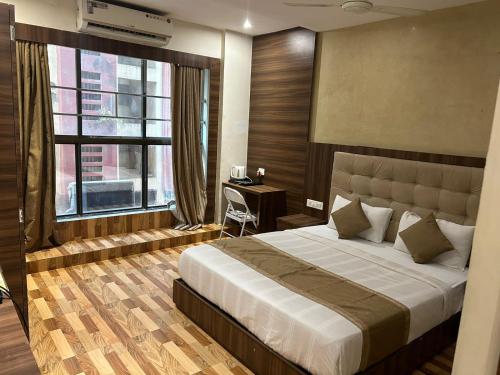 孟买Hotel BKC Mannat的一间卧室配有一张床、一张书桌和一个窗户。