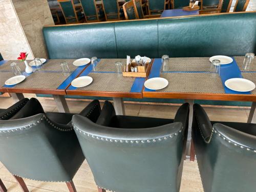 斋浦尔Hotel Vinnie的餐厅里一张桌子,上面摆放着盘子和椅子