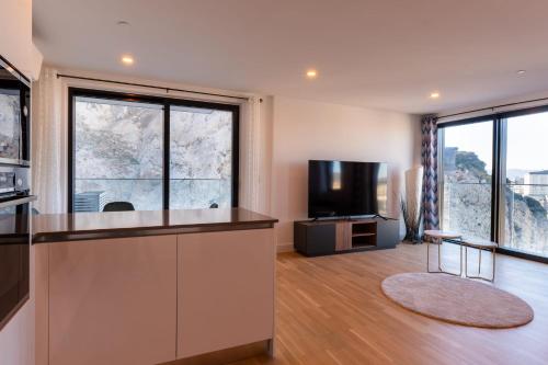 直布罗陀FORBES Suite1206-Hosted by Sweetstay的厨房配有柜台、电视和一些窗户。