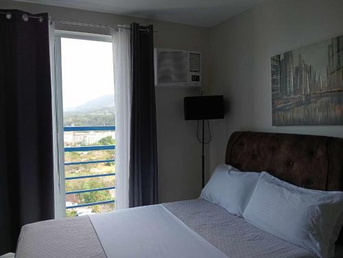 卡加盐德奥罗Loop Spacious Studio Unit的一间卧室设有一张床和一个美景窗户。