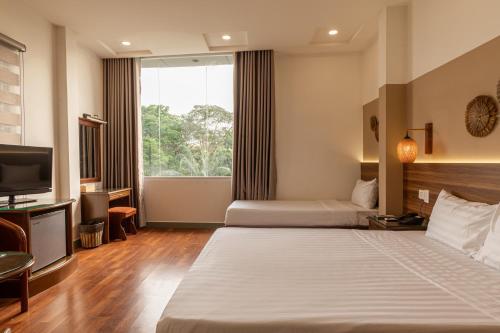 胡志明市Lantern Hotel的酒店客房设有两张床和电视。