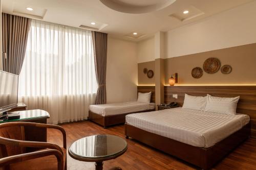 胡志明市Lantern Hotel的酒店客房配有一张床铺和一张桌子。