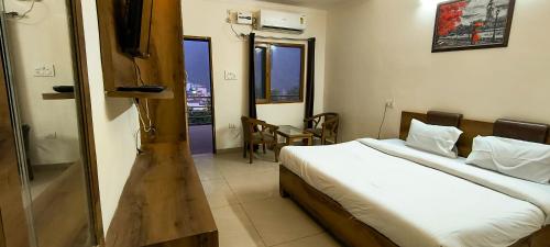 瑞诗凯诗Hotel Grace Ganga的一间卧室配有两张床和一张桌子及椅子