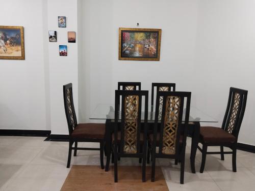 拉合尔King's Paradise的一间用餐室,配有黑色的桌子和椅子