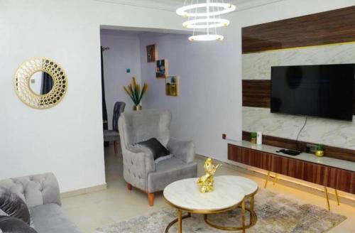 哈科特港Owtee’s Apartments的带沙发、桌子和电视的客厅