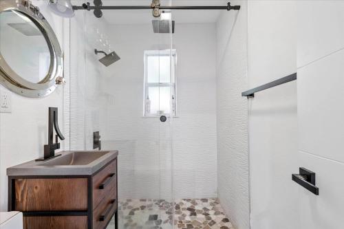 劳德代尔堡Private Fort Lauderdale cottage的带淋浴、盥洗盆和镜子的浴室