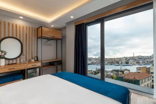 伊斯坦布尔Union Hotel Karaköy的卧室设有大窗户,享有城市美景。