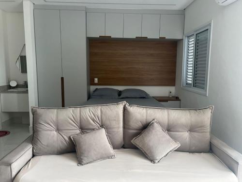 圣贝尔纳多-杜坎普Apartamento Studio em São Bernardo的卧室内一张带两个枕头的沙发