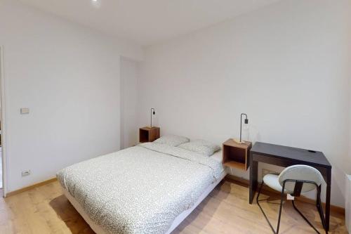 勒阿弗尔Marechal Joffre - RDC - Grand F2的一间卧室配有一张床、一张桌子和一把椅子