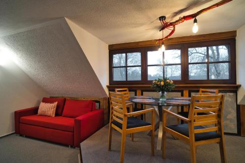 新格洛布索Luisenhof的客厅配有桌子和红色沙发