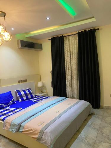 KusafeZurik Apartments的一间卧室配有一张大床和黑色窗帘