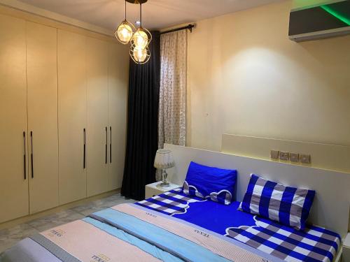 KusafeZurik Apartments的一间卧室配有一张带蓝色和白色枕头的床