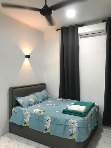 Pasir MasAINUL HOMESTAY的一间卧室配有一张带蓝色床单的床和吊扇。