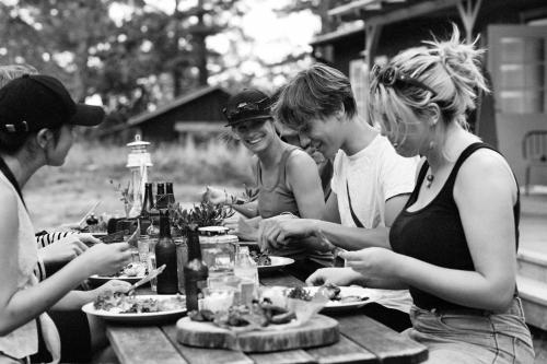 格林达Grinda Stugby och Sea Lodge - Pensionat med kost & logi的一群人坐在野餐桌旁吃食物