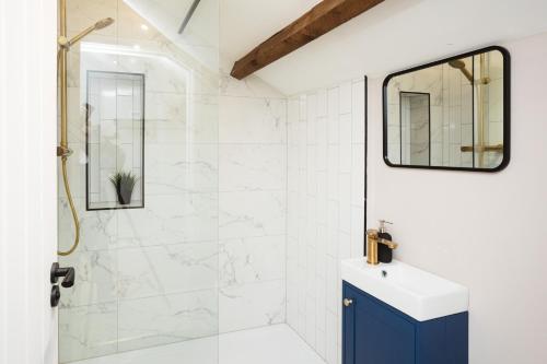 查珀伦勒弗里斯Bankers Room + Kitchenette的带淋浴和蓝色橱柜的浴室