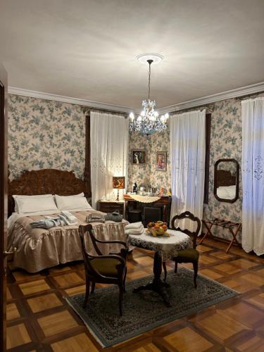 帕多瓦Villa Carla - Camera King Superior的卧室配有一张床和一张桌子及椅子