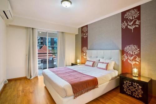 丰沙尔Apartamento Caires的一间带大床的卧室和一个阳台